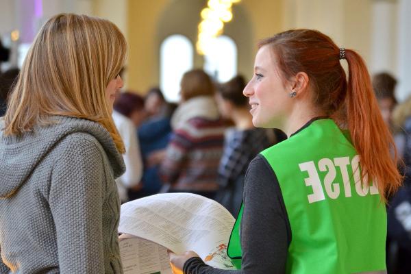 Eine Helferin erklärt einer Studentin etwas auf dem LMU Campustag.