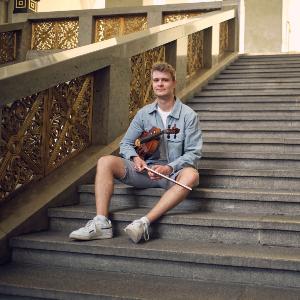 Janik Ludwig spielt Geige im Hauptgebäude der LMU