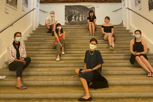 Studierende sitzen mit der Dozentin Krämder de Huerta auf einer Treppe im Museum Fünf Kontinente