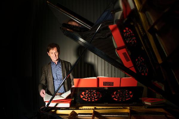 Professor Hartmut Schick steht vor einem Klavier.
