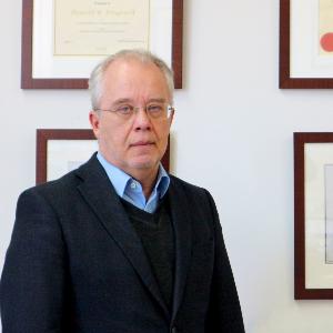 Portrait von Prof. Dr. Donald Bruce Dingwell vor einer Wand mit eingerahmten Urkunden.