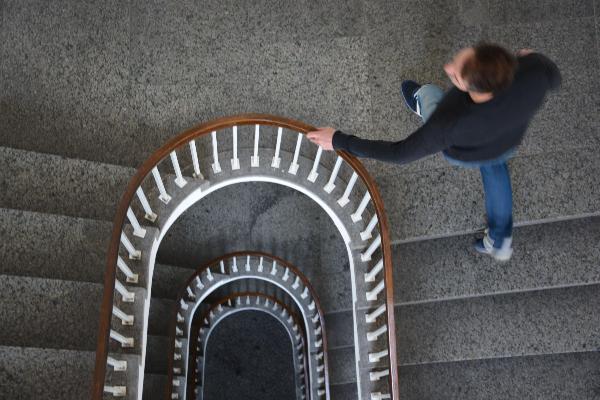 Ein Mann läuft eine Treppe an der LMU hinauf.