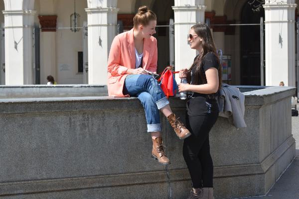 Zwei Frauen unterhalten sich am Brunnen auf dem Geschwister-Scholl-Platz.