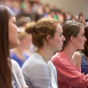 Studentinnen sitzen konzentriert bei einer Vorlesung nebeneinander.