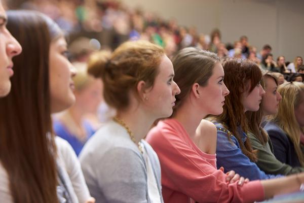 Studentinnen sitzen konzentriert bei einer Vorlesung nebeneinander.