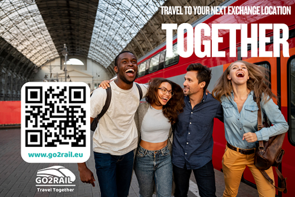 Group of four laughing students standing on a railway platform at a station