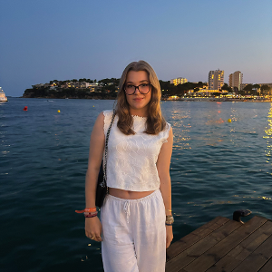 Studentische Tutorin, die an der Küste steht mit Meer im Hintergrund