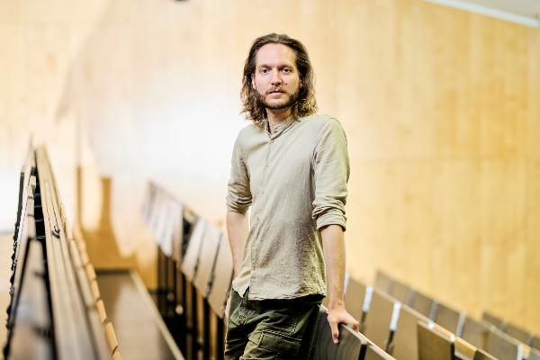 Philipp Wicke steht in einem Hörsaal