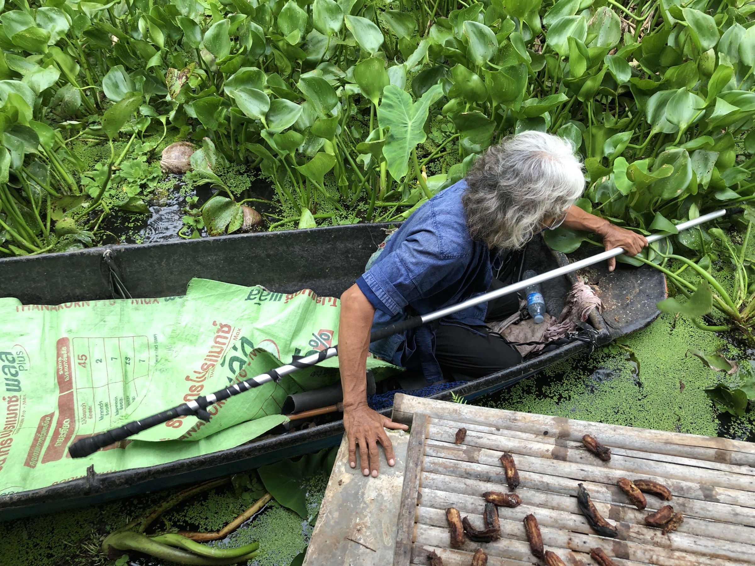 Ein thailändischer Farmer unterwegs mit dem Boot.