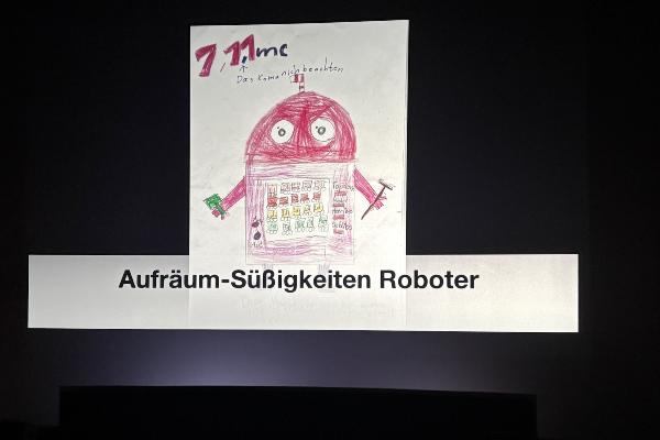 A child´s drawing of a Candy Cleanup Robot displayed on a large screen.