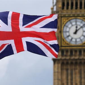 A British national flag flies in front of the Big Ben clock tower in London