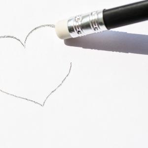 A heart drawn in pencil on paper is erased