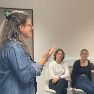 Eine Dozierende in Gebärdensprache und drei Seminarteilnehmerinnen
