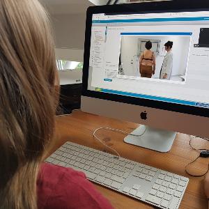 Frau schaut auf Computerbildschirm ein medizinisches Fallbeispiel an