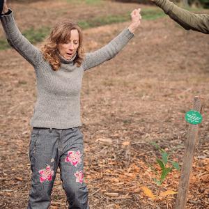 LMU-Vizepräsidentin Francesca Biagini freut sich über den neu gepflanzten Baum im Universitätswald bei Landshut.