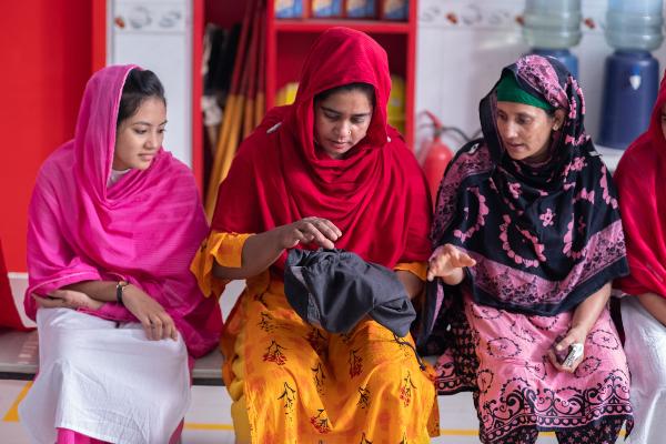 Garment workers look at a menstrual hygiene dry bag as part of a training course