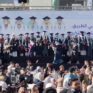 Abschlussfeier von Studierenden der medizinischen Fakultäten der Universitäten des Gazastreifens im Krankenhaus „Die Heilung“ in der Stadt Gaza im Januar 2026. Die Schrift lautet „Sie waren mit uns auf dem Weg … / und haben die Tribüne der Abschlussfeier verpasst“ und erinnert an die während des Studiums umgekommenen Kommilitoninnen und Kommilitonen.