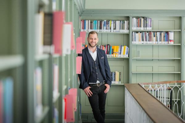 Porträt des Philosophen Timo Greger, Referent der KI Lectures, in einer Bibliothek