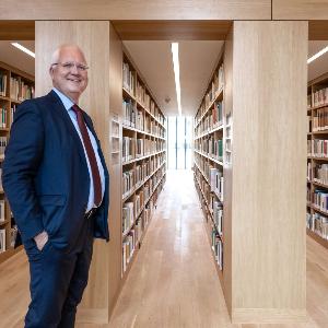 Professor Oliver Jahraus vor Bücherregalen im Philologicum