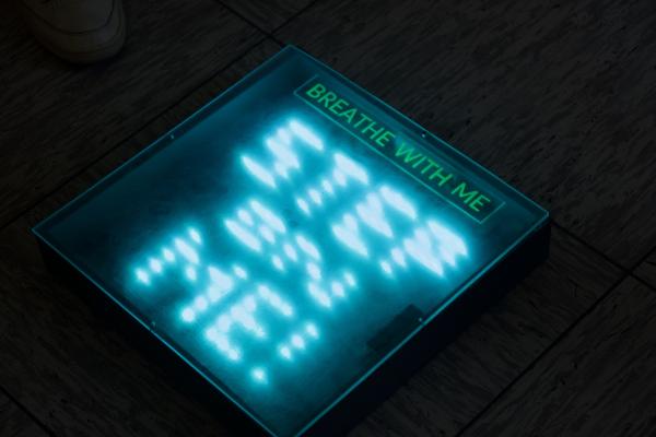 A floor tile with illuminated lettering for public spaces