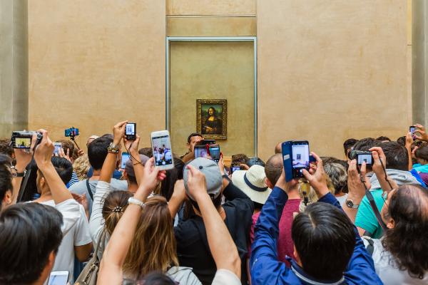 Visitors take photo of Mona Lisa at the Louvre Museum.