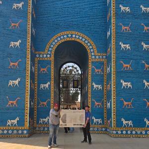 Zwei Männer stehen vor der Replik des Ischtar-Tors in Babylon