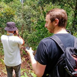 Christopher Klapperich steht mit zwei Wissenschaftlern in einem Wald auf den Philippinen.