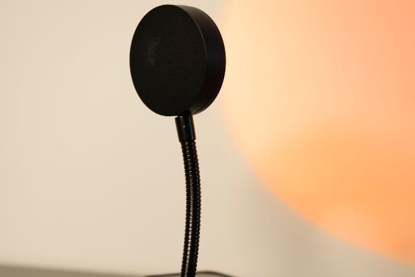 A black lamp on a desk casts a glow.