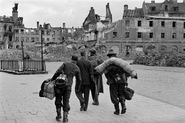 Deutsche Soldaten kehren aus dem Krieg zurück, im Hintergrund die zerstörte Münchner Innenstadt, aufgenommen am 13.Juli 1945.