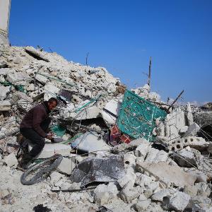 Syrer auf den Trümmern eines durch ein Erdbeben zerstörten Hauses in Atarib