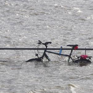 Ein Fahrrad ist nach einer Sturmflut halb überspült.