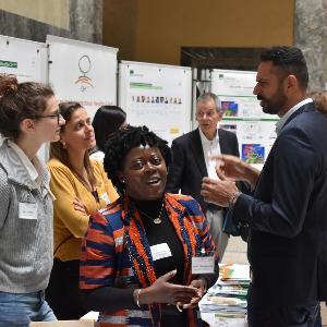 Teilnehmende des Global Health Day 2024 diskutieren an einem Informationsstand