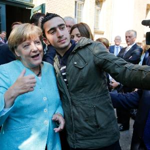 Anas Modamani macht ein Selfie mit Bundeskanzlerin Angela Merkel