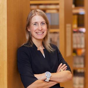 Prof. Susanne Reichlin leans against a bookshelf in the Philologicum