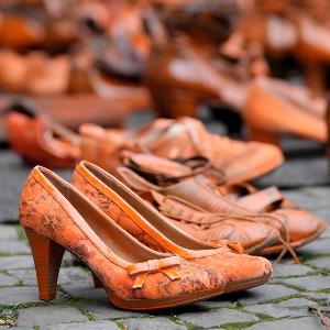 Orangefarbene Schuhe auf einem Bürgersteig in Köln sollten am Orange Day 2024 auf jede versuchte oder erfolgreiche Tötung von Frauen hinweisen