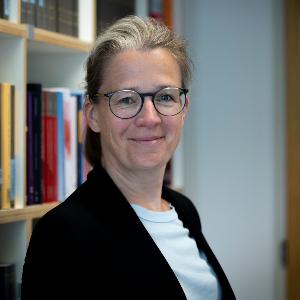 Prof. Dr. Ann-Katrin Kaufhold steht vor einem Bücheregal