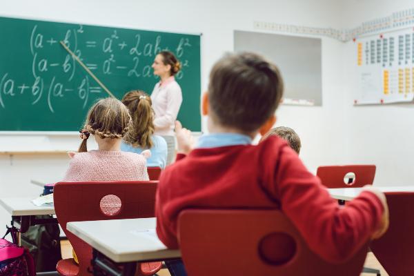 Schüler sitzen im Unterricht an ihren Plätzen, die Lehrerin steht erklärend vor der Tafel. | © PantherMedia / Arne Trautmann Schüler sitzen im Unterricht an ihren Plätzen, die Lehrerin steht erklärend vor der Tafel.