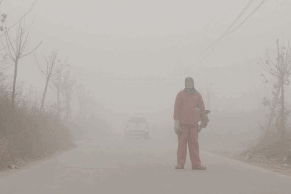 Mann steht kaum sichtbar im Smog Mann steht kaum sichtbar im Smog