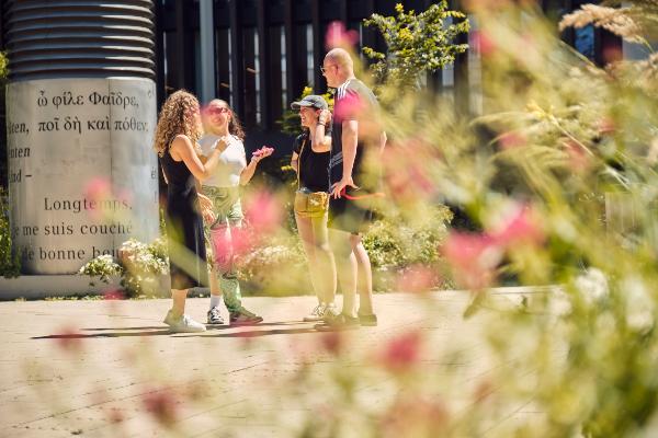 Vier Studierende stehen zusammen und unterhalten sich.