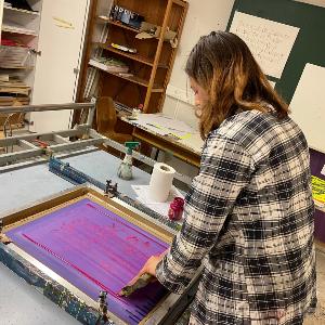 Studierende der Kunstwissenschaft in der Siebdruckwerkstatt beim Drucken ihrer Arbeit
