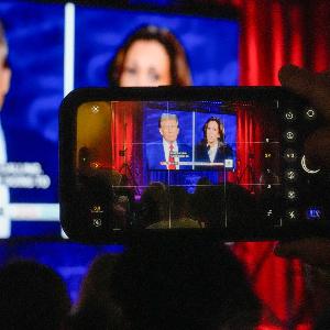 Blick auf die TV-Debatte zwischen Trump und Harris durch ein Smartphone