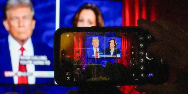 Blick auf die TV-Debatte zwischen Trump und Harris durch ein Smartphone