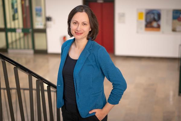 Professor Mirjana Sakradzija is standing in the stairwell of the building on Luisenstraße. She is looking at the camera with her left hand half in her trouser pocket.